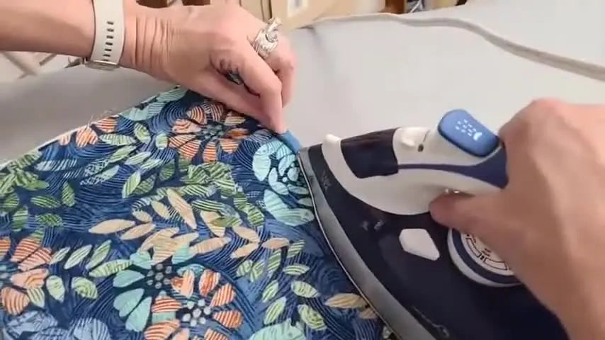 Iron pressing fusible quilt binding in place.