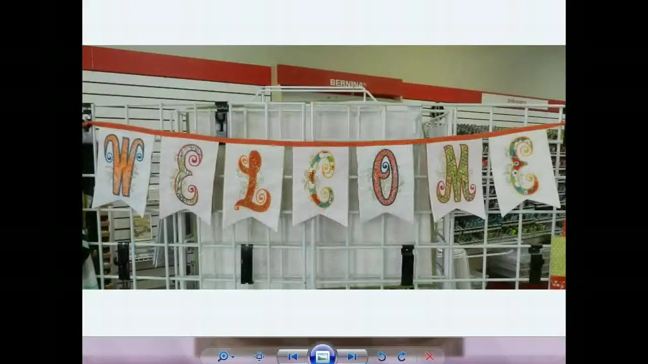 A finished “WELCOME” bunting banner hangs neatly, showing crisp points and consistent flag sizing across the set.