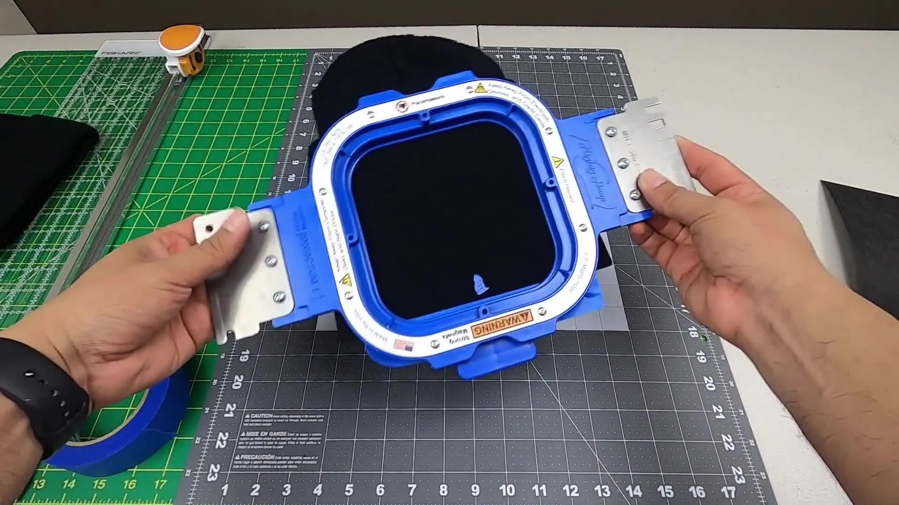 A knit beanie clamped cleanly in a 5.5-inch magnetic hoop with the center mark aligned and ready for stitching.