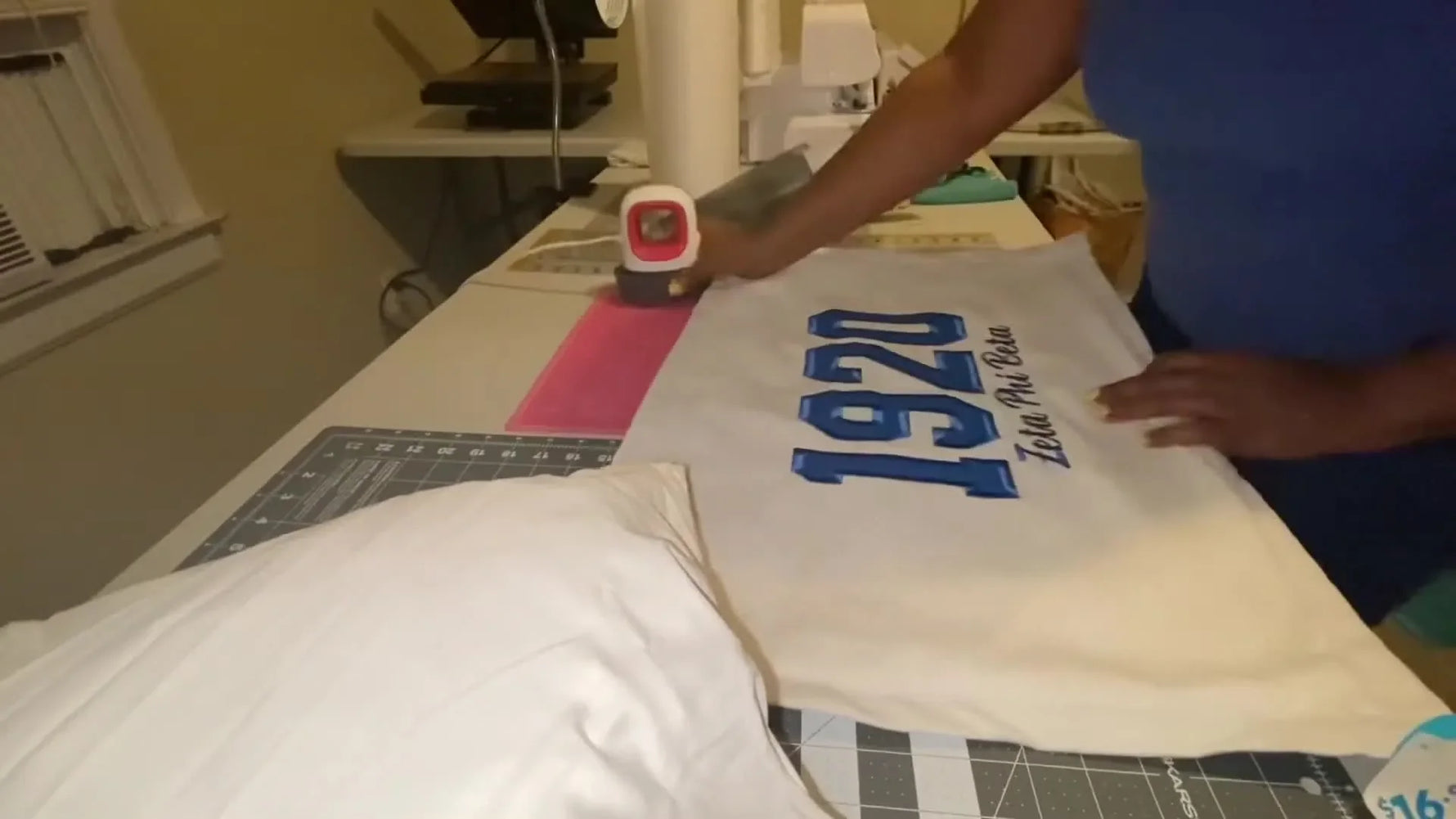 An overhead view of the finished pillow showing bold blue appliqué numbers and clean satin borders on a textured white pillowcase.