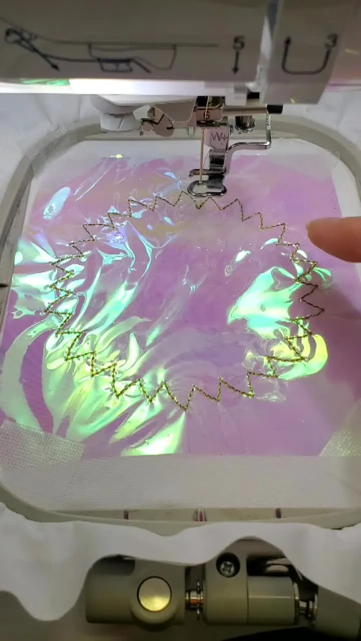A close-up of the machine stitching yellow sunflower petals while the iridescent Mylar sheen glows through the low-density fill.