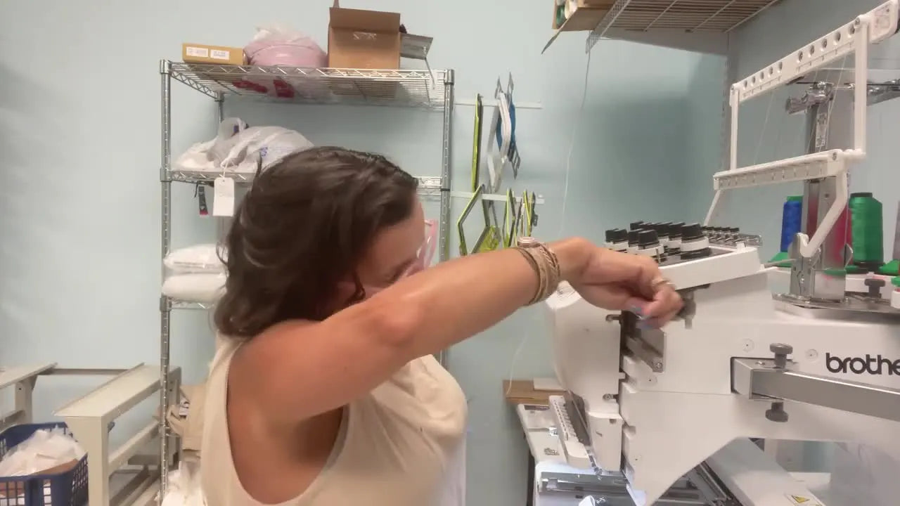 A close-up of the Brother Entrepreneur Pro X side opening where the presenter points to the exact internal gear that locks and triggers the needle case motor error.