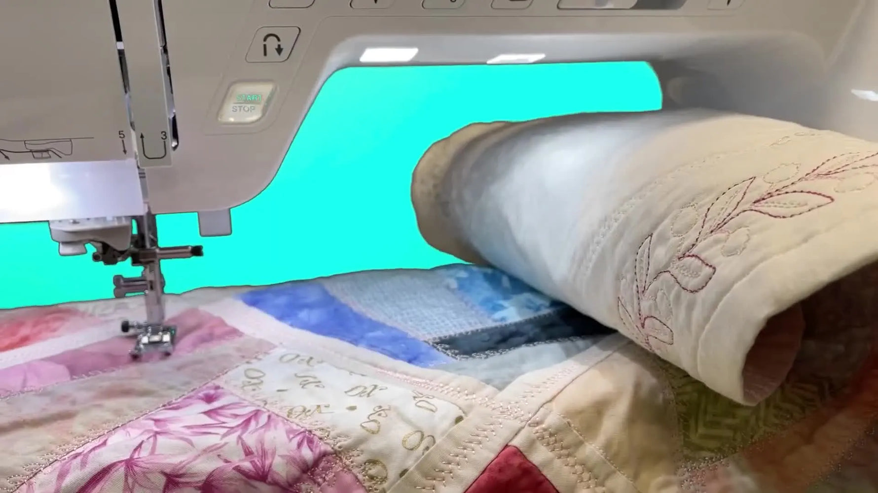 A Baby Lock Ballad sits in front of a large quilt, emphasizing the generous throat space for quilting and bulky projects.