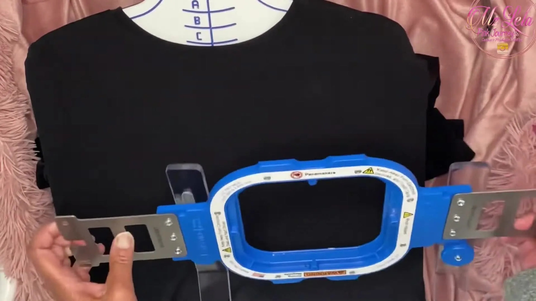 A top-down action shot of the magnetic hoop snapping onto a shirt on the hooping station for a fast, secure clamp.