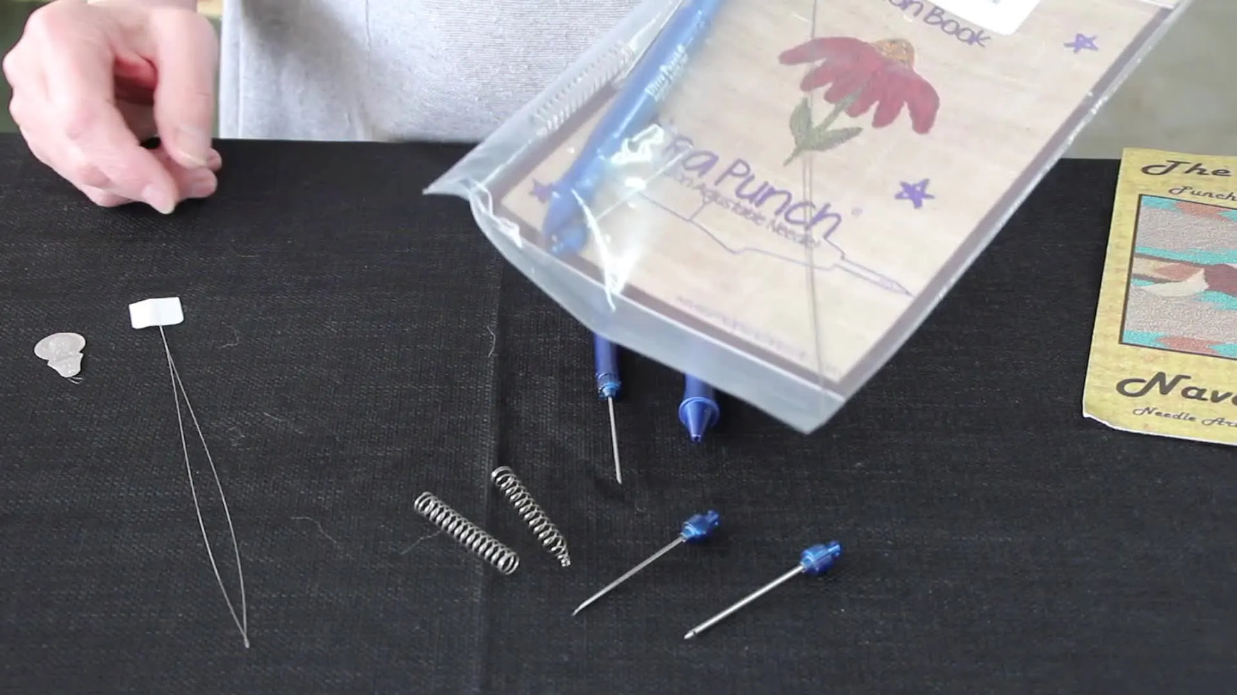 Ultra Punch Needle set and accessories spread out on a black surface