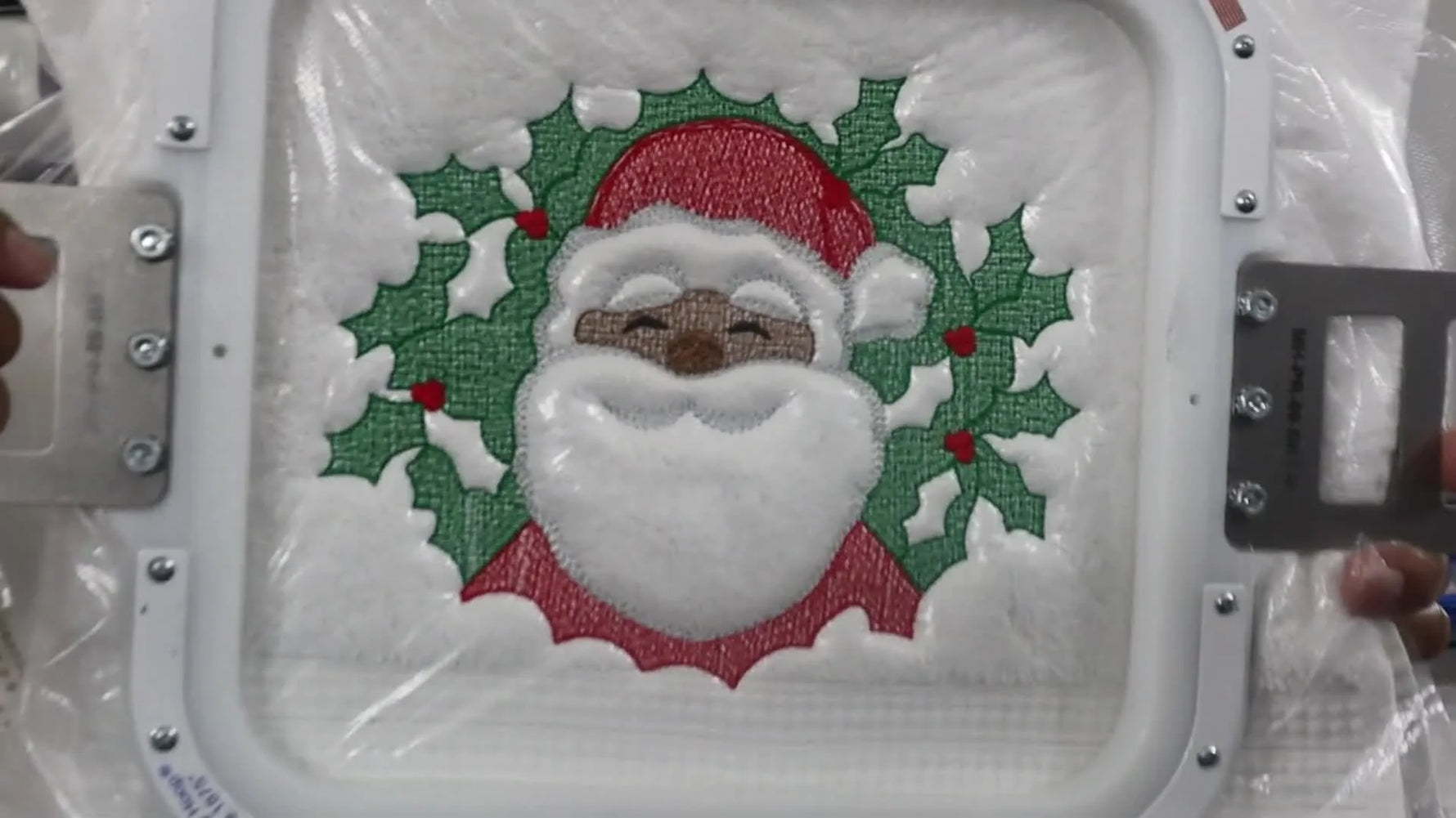 A close-up of the finished Santa towel after unhooping, with the water-soluble topper removed to reveal a raised, embossed texture.