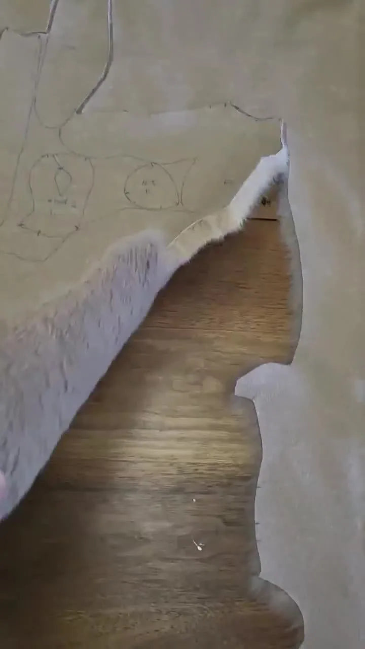 A completed, soft, floppy-eared plush rabbit sitting on a pink bedspread.