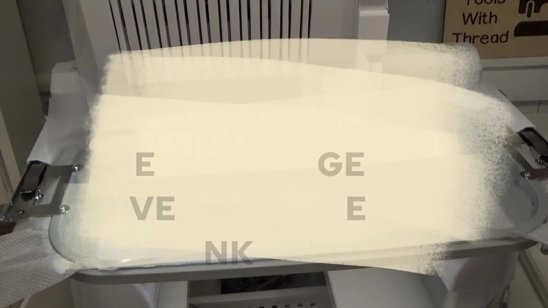A close-up of the Brother PR1055X actively stitching a “Grateful” block on yellow fabric inside a large multi-needle hoop.