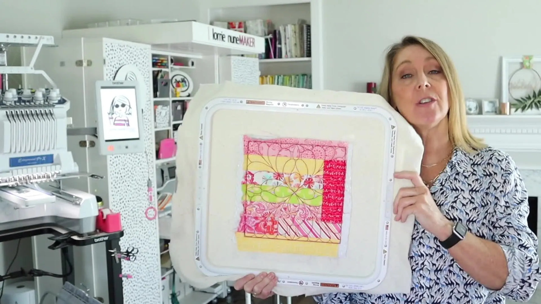 A large 14x16 magnetic hoop is held up beside a finished quilt block to show the expanded embroidery field and the clean center join.