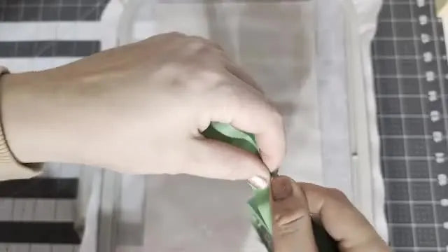 Hands apply green masking tape to float the base fabric on hooped tear-away stabilizer for an ITH organizer on the Baby Lock Altair 2.