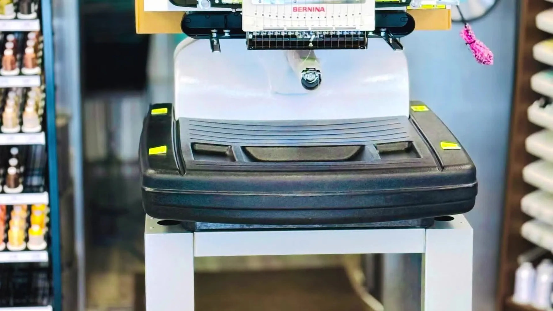 A Bernina multi-needle embroidery machine sits securely on a fully assembled Melco stand, showing the final stable setup.