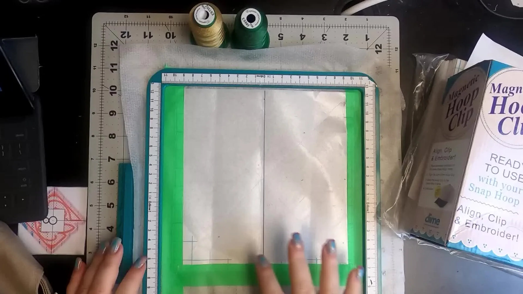 A baseball cap is pressed flat onto sticky stabilizer in an 8x8 Snap Hoop, showing the key moment where alignment and adhesion prevent shifting.