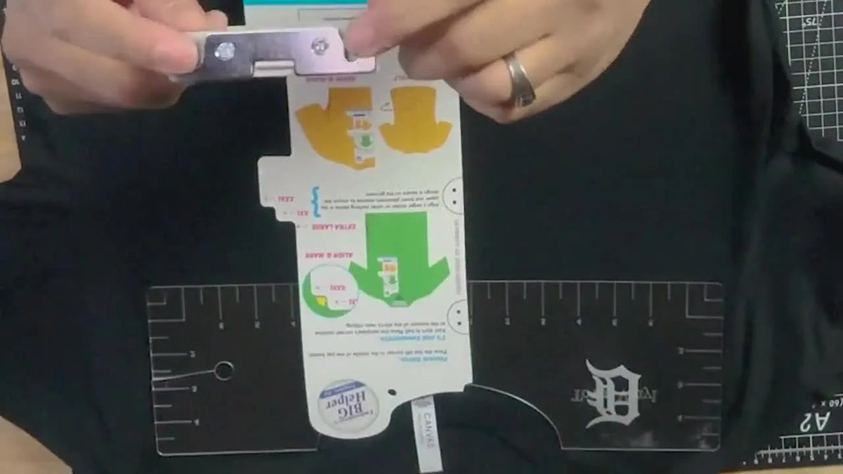 Hands aligning hoop frame with ruler.