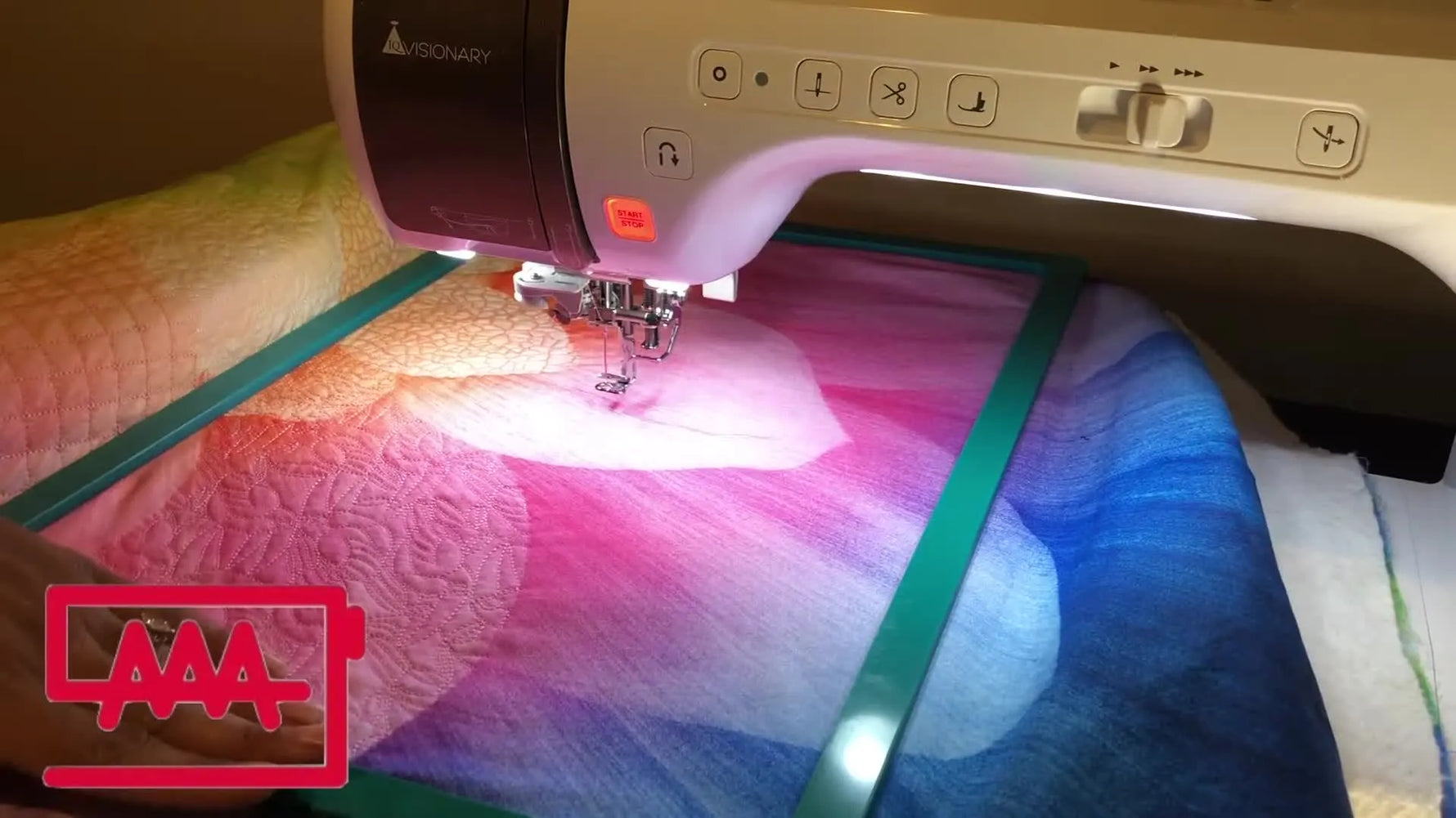 A close-up of a green magnetic hoop holding a quilt sandwich (top, batting, backing) ready for IQ Designer quilting on a Baby Lock Visionary.