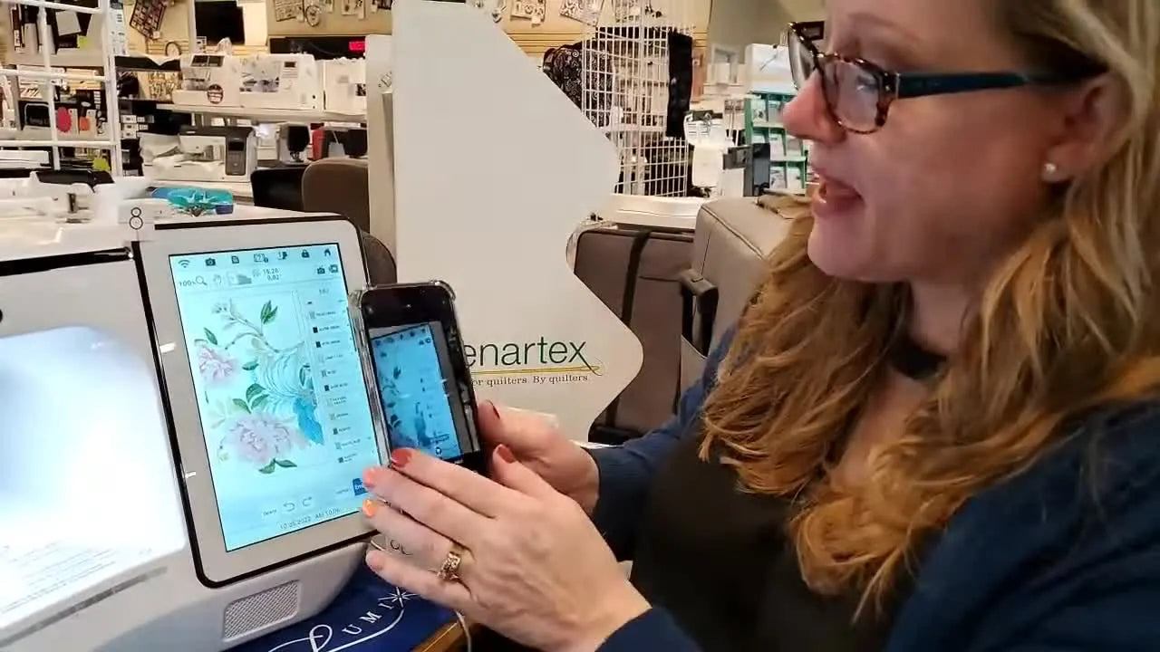 A close-up of a smartphone photographing the Brother Luminaire XP3 screen so the full embroidery color list can be referenced at the thread rack.