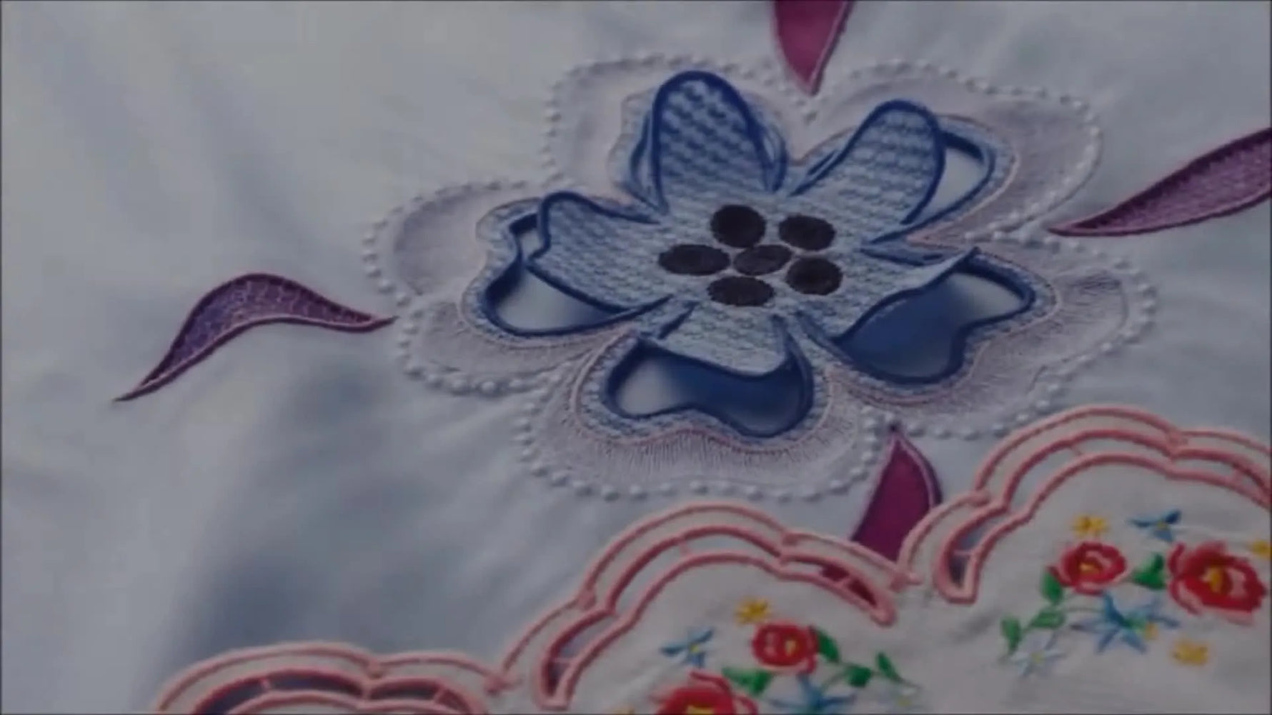 Finished cutwork flower embroidery on light blue fabric