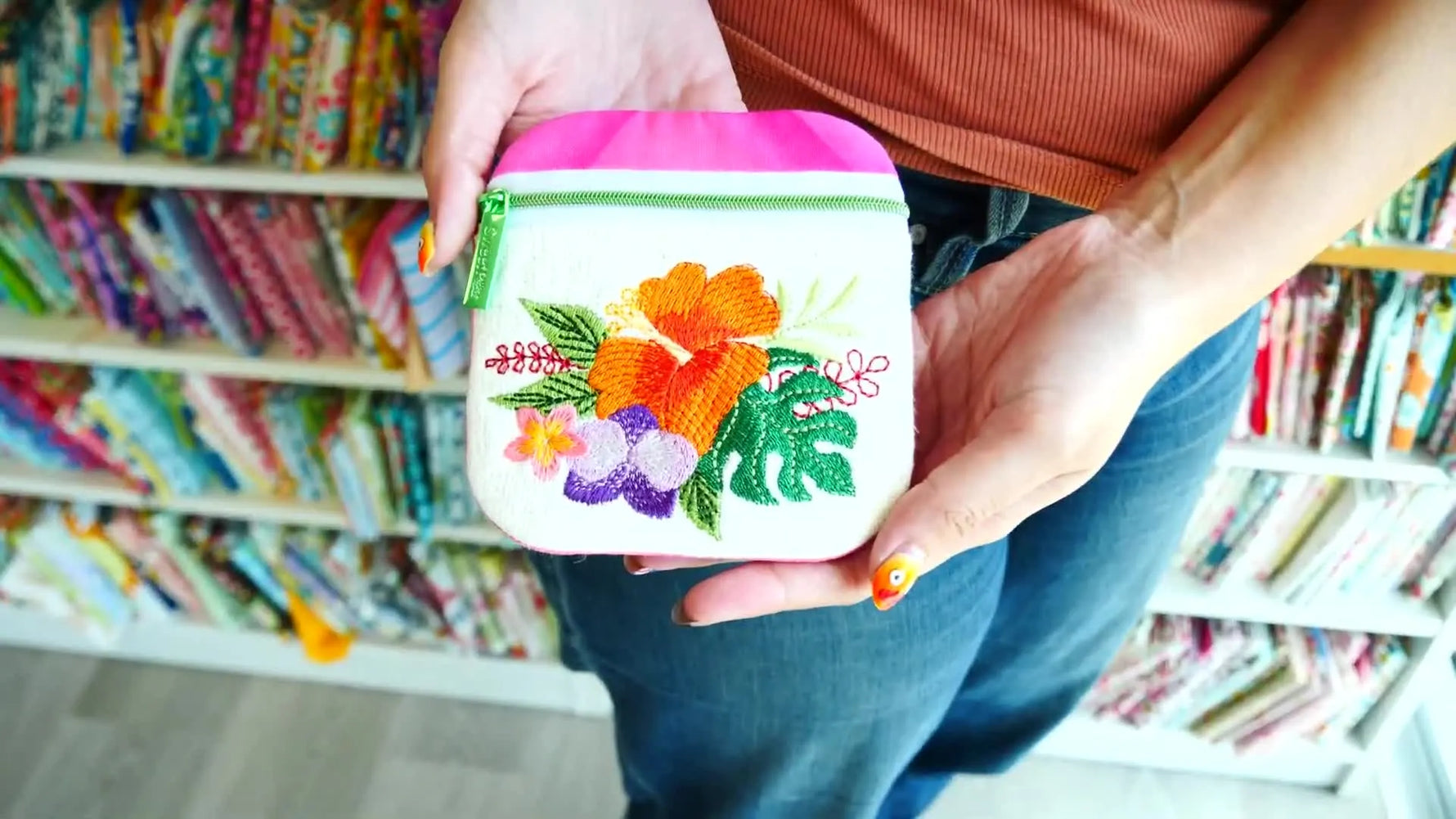A close-up of the finished Tropical Flowers ITH purse showing vibrant hibiscus embroidery and a clean zipper finish.