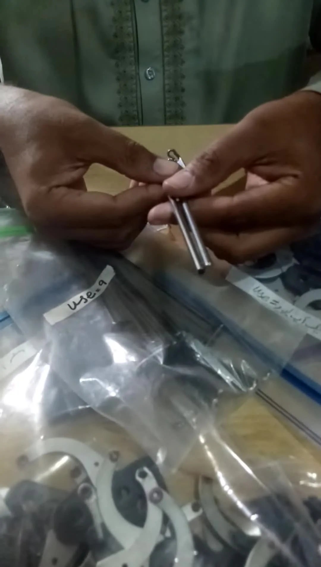 A side-by-side close-up comparison of a genuine black-finish pin versus a shiny non-genuine pin to highlight surface quality differences.