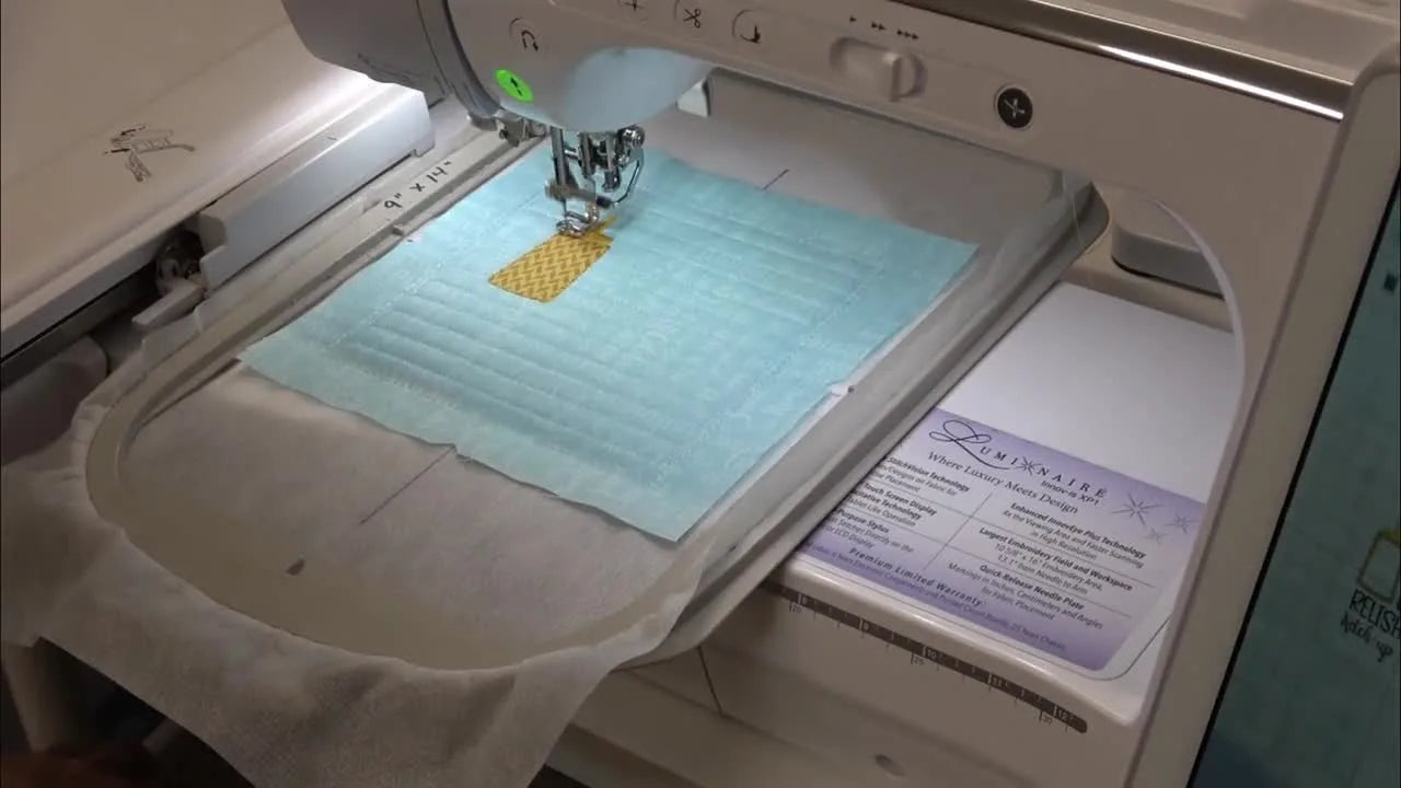 A macro close-up shows the Brother Luminaire stitching the yellow criss-cross detail on the mustard bottle during the in-the-hoop appliqué block.