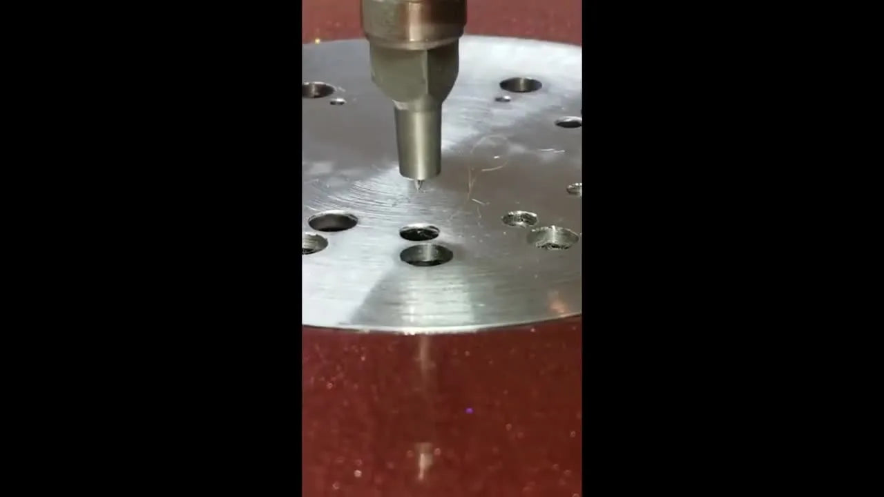 Close-up of the needle tip protruding one millimeter at the plate.