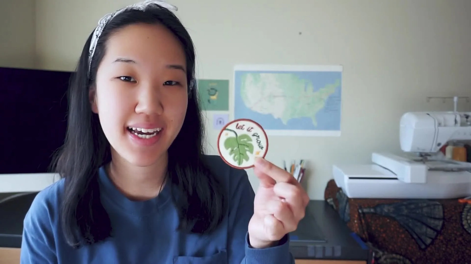 Woman holding up a completed custom patch with a Monstera leaf design.