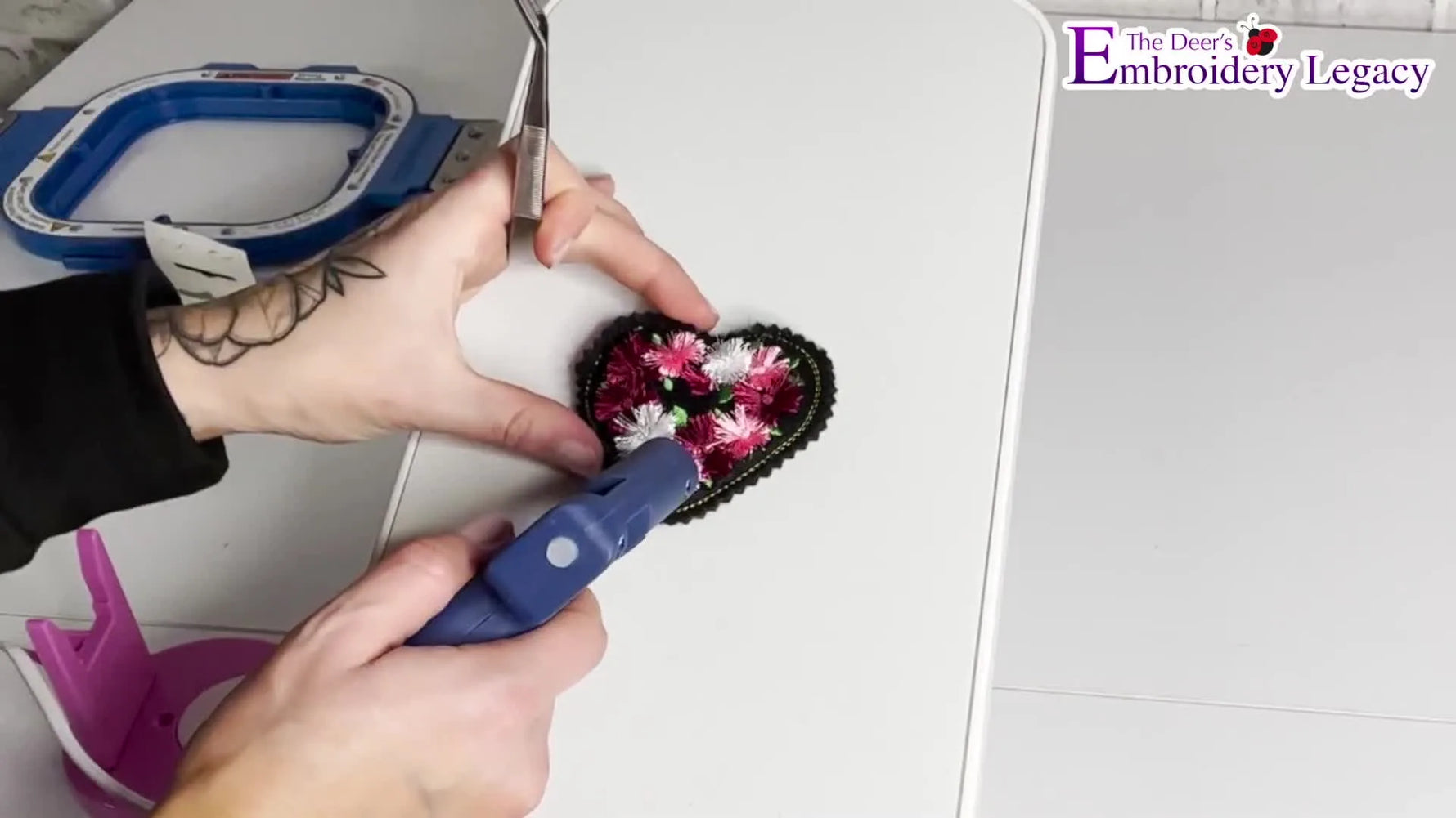 A finished fringe-flower heart brooch pinned on a sweatshirt, showing the 3D fringe texture and clean ITH outline.