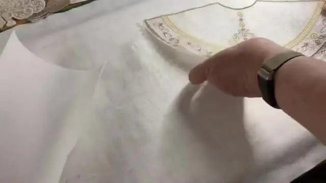 A wide view of the embroidered angel bodice being aligned on top of the stiffening skirt cone to confirm the angel will stand straight and balanced.