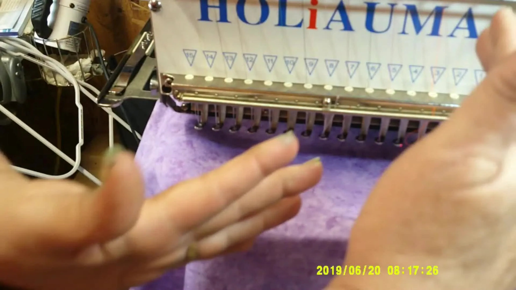 Close-up of fabric being folded into an inverted pleat inside the hoop while the machine is ready to tack the fold down.
