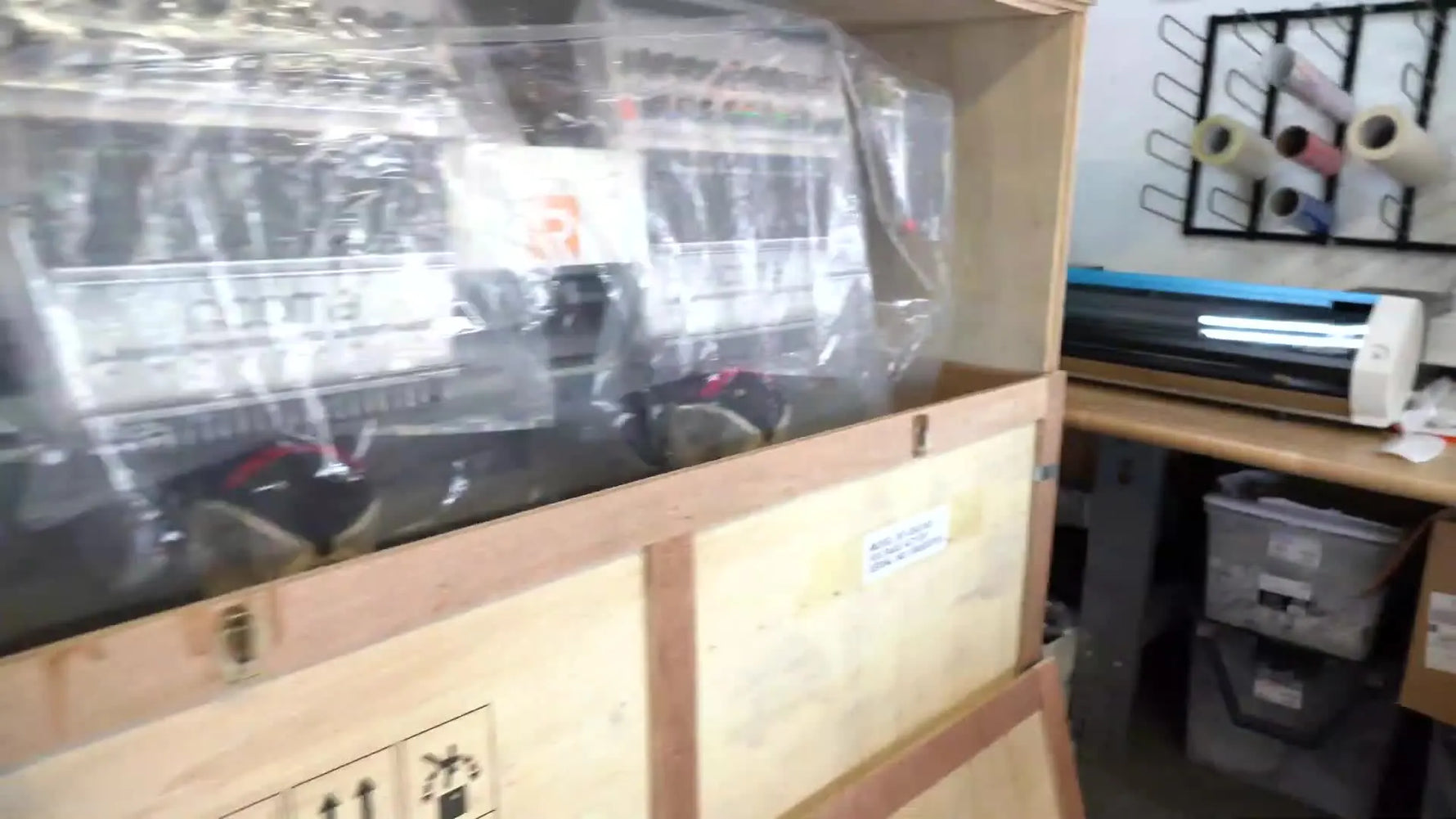 The Ricoma MT-2002 two-head embroidery machine is revealed inside the opened shipping crate, still wrapped in protective plastic.