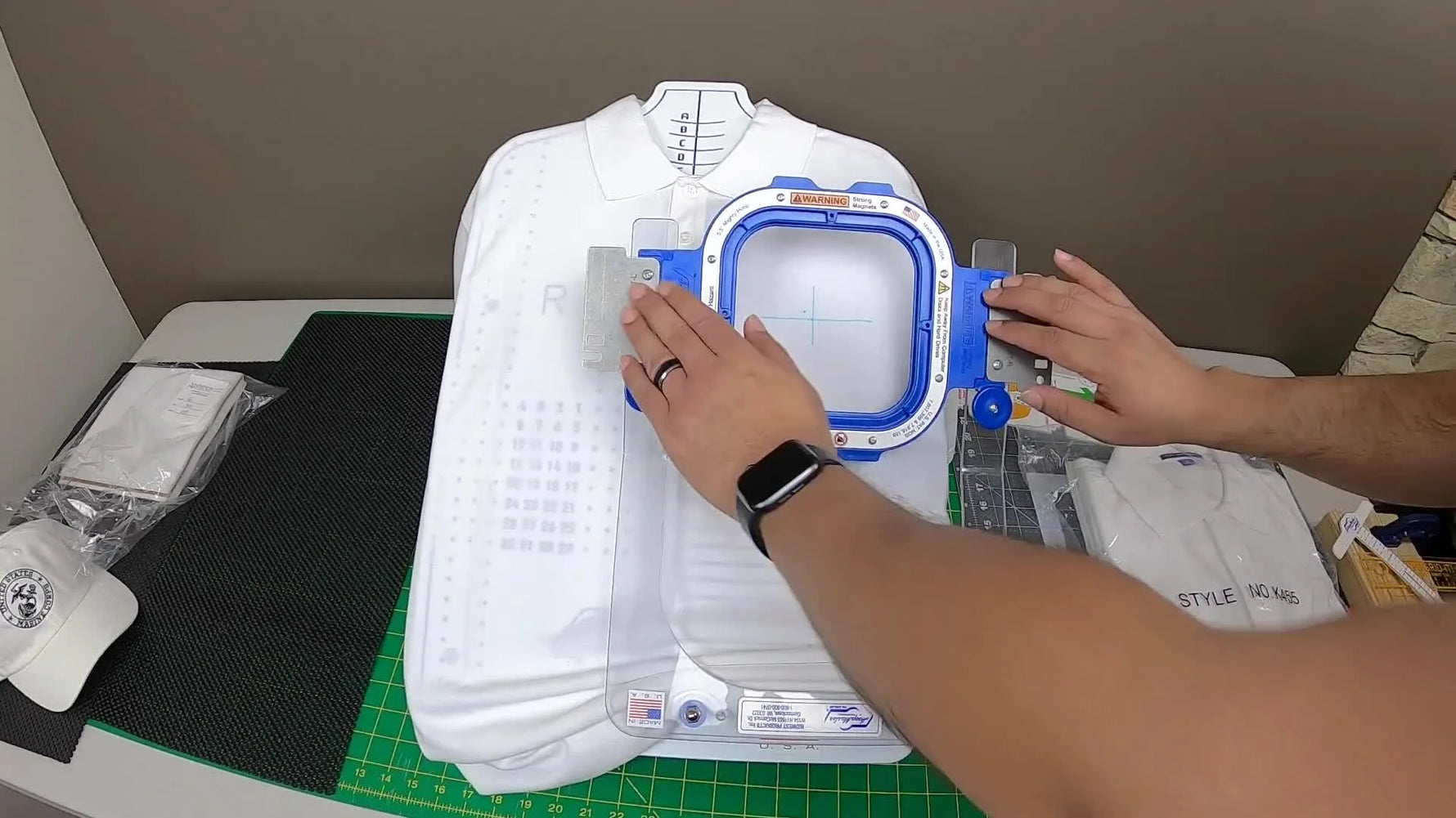 A 5.5-inch magnetic hoop is snapped shut on a polo shirt at the hooping station, clamping the fabric cleanly for a fast left-chest logo setup.