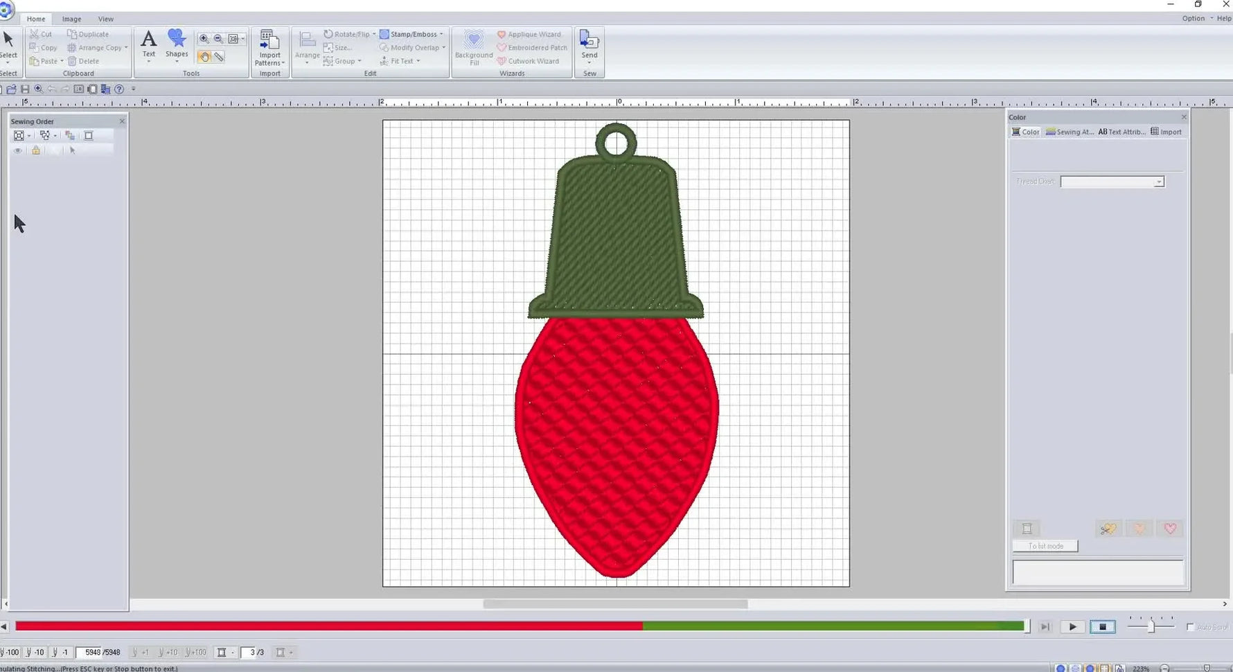 A completed FSL Christmas light bulb design is shown on the embroidery software grid with the red bulb, green cap, and top loop clearly visible.