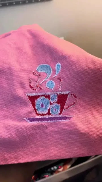 Close-up of pink fabric showing white bobbin thread visible through pink stitches.