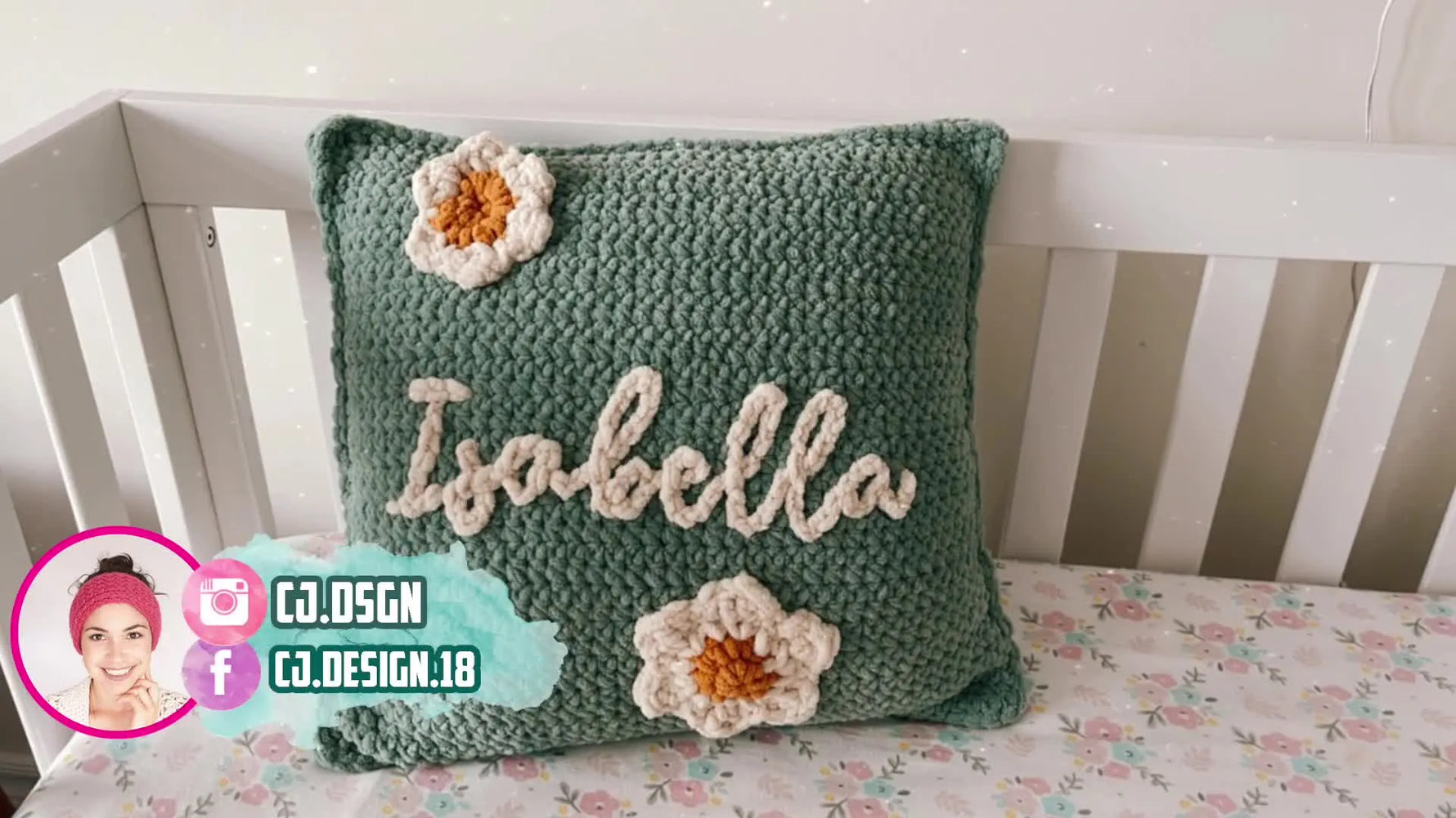 Finished green crochet pillow with 'Isabella' stitched in cream yarn and two small flower appliqués.