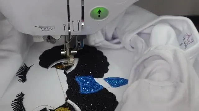 A finished unicorn appliqué kids’ shirt with a stitched name, shown laid flat as the final result.
