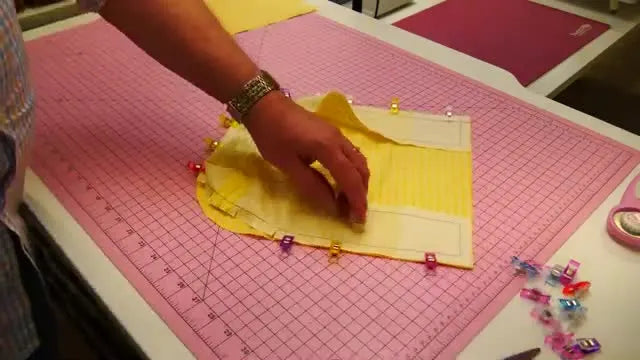 A clipped curved gusset edge is fanned out and held with clips to match the main panel curve before stitching.