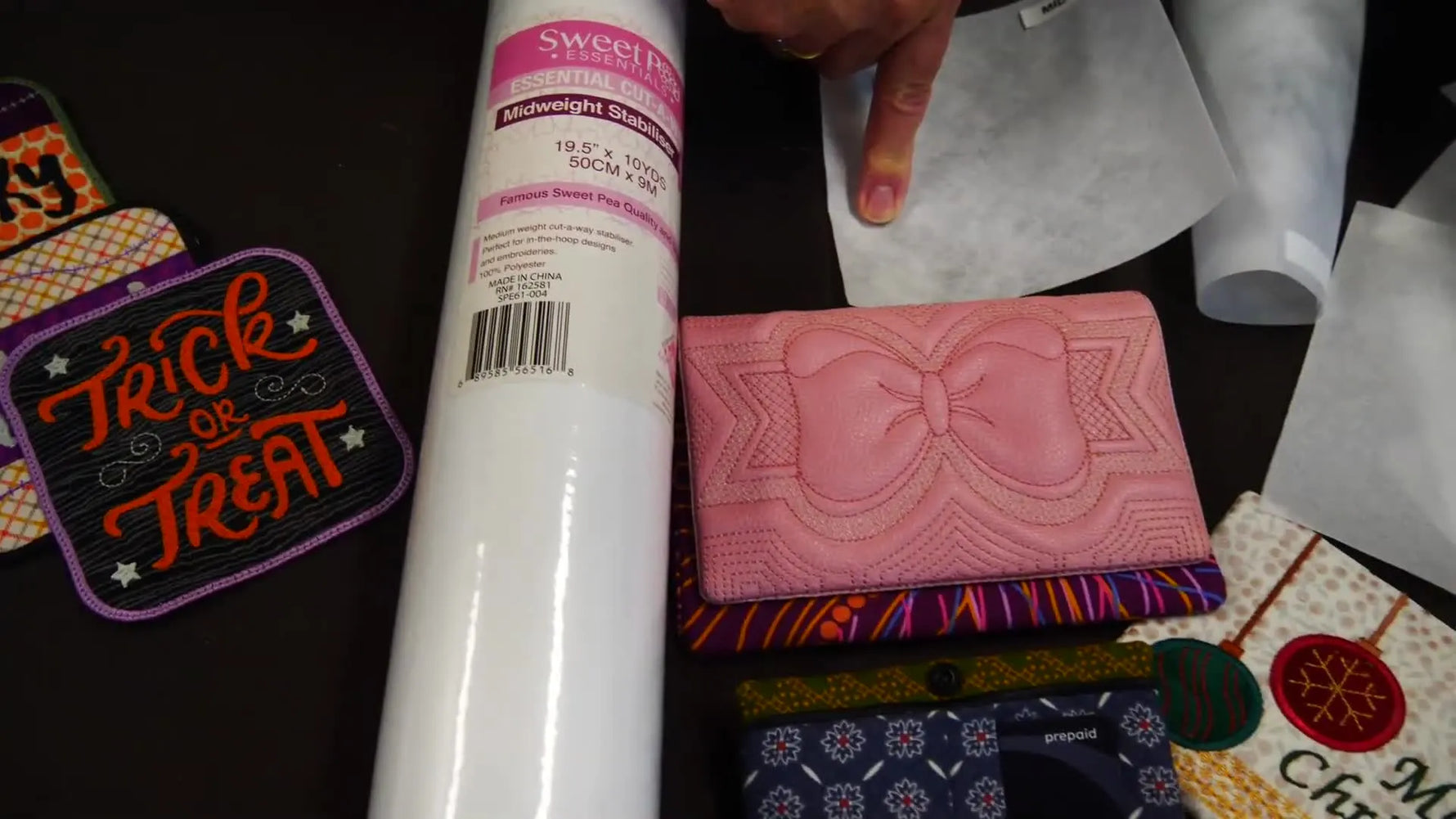 Martyn holds the Bag Stabilizer roll during the product reveal, highlighting a thin-but-rigid foam alternative for structured embroidery bags.