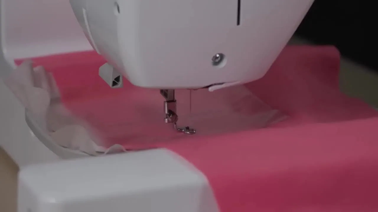 A close-up of the needle stitching through the fleece, water-soluble topper, and wash-away stabilizer stack as the embossed design begins.