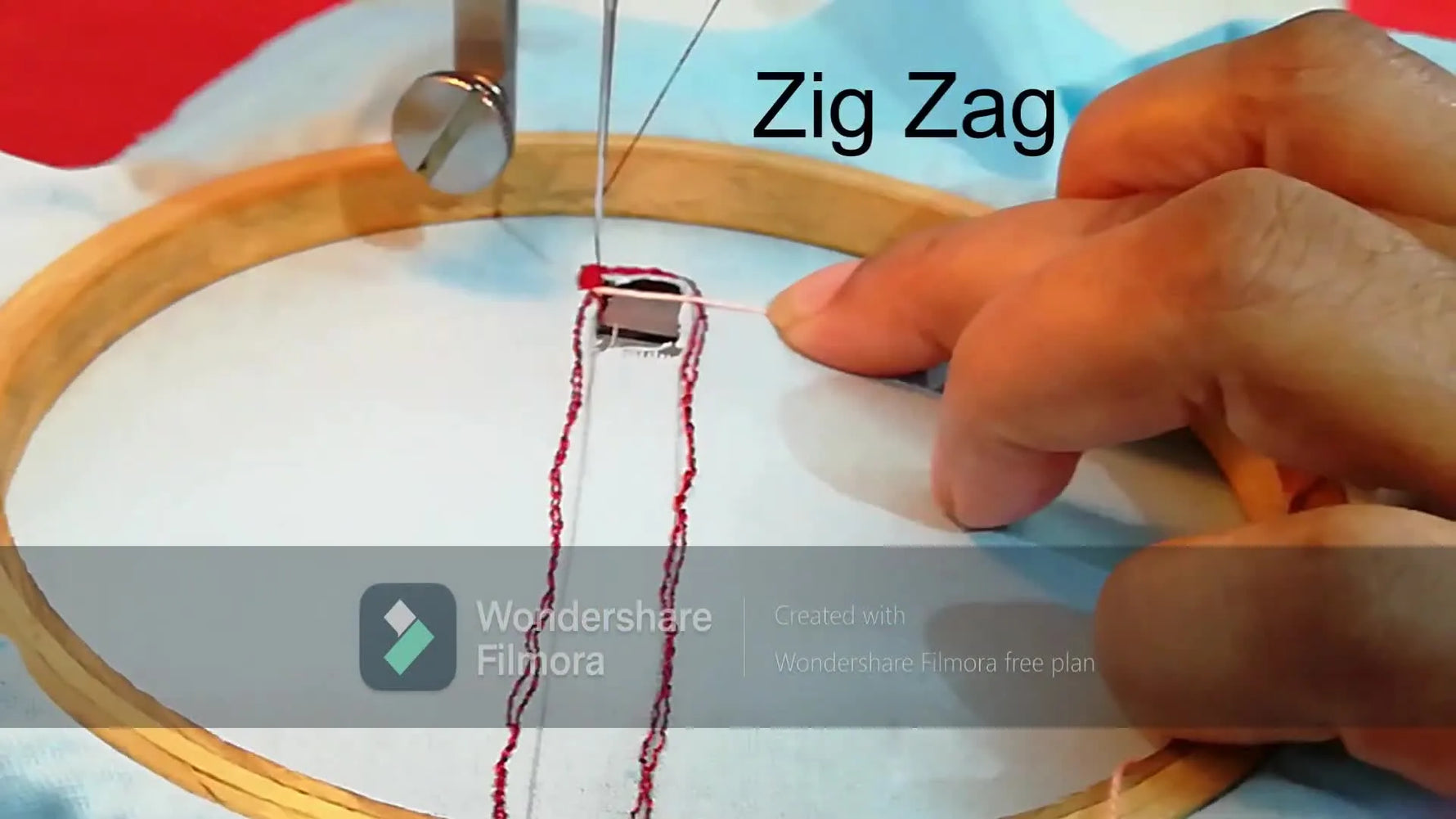 An extreme close-up of the needle zig-zagging over pink twine to bridge a rectangular cutwork opening.