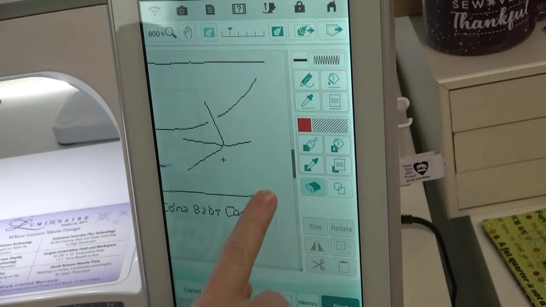A close-up of the Luminaire touchscreen as stray scan artifacts are erased to leave only clean chick-foot linework ready for stitch conversion.