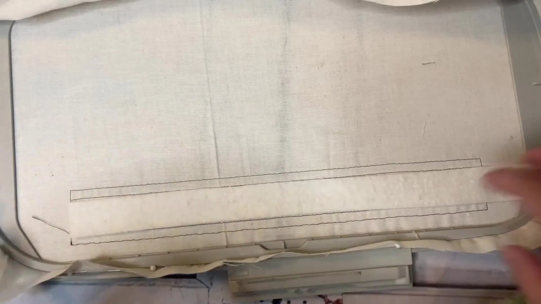 Overhead view of a 7x12 hoop as a new batting strip is aligned for the second hooping to keep the quilting border continuous.
