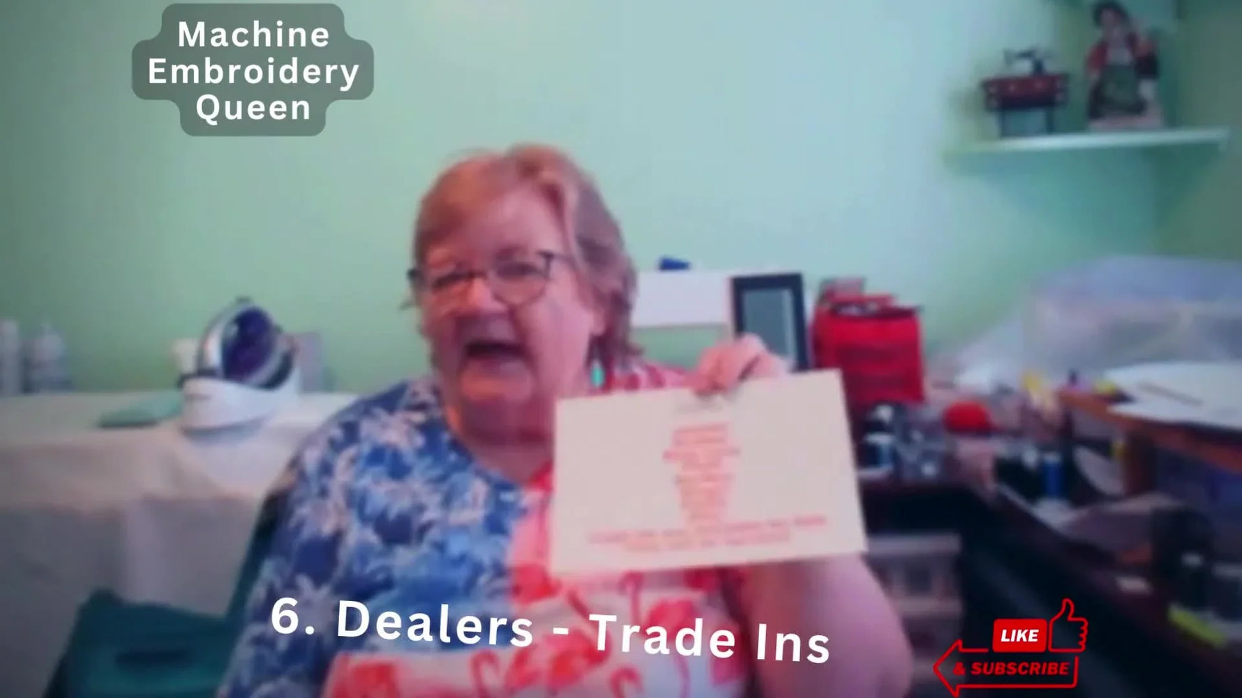 Mary holds up a “Dealers – Trade Ins” card while explaining why refurbished trade-ins can be a safer used-machine purchase.