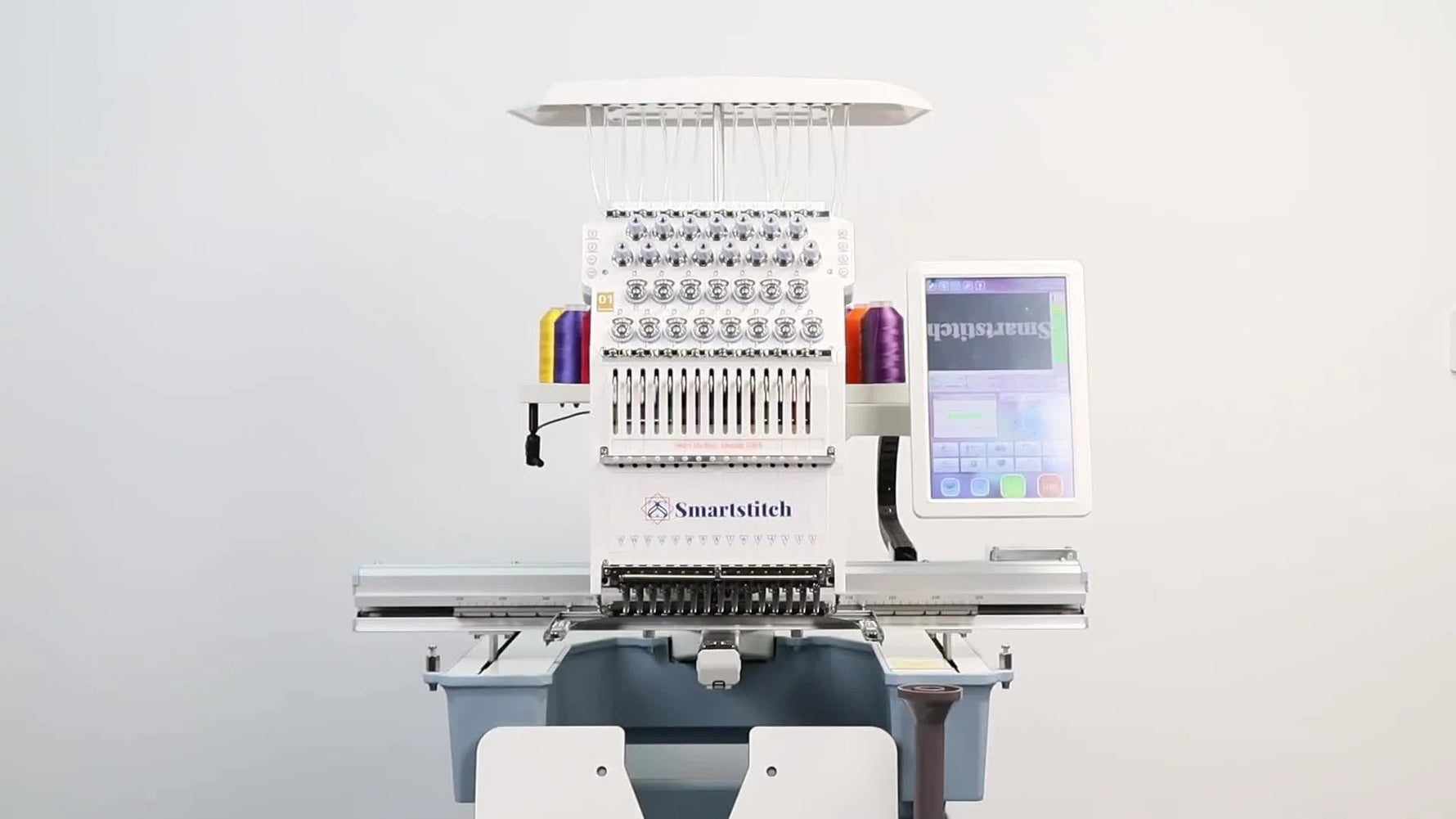 A wide view of a Smartstitch multi-needle embroidery machine upgraded with an extended table and a large aluminum sash frame holding a floral design.