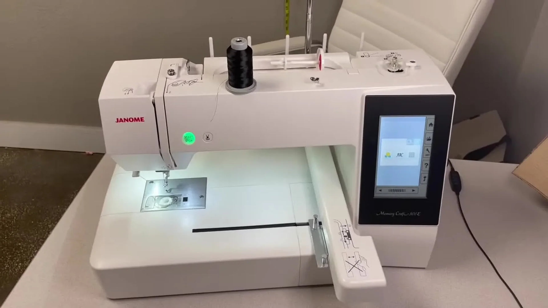 A wide, clean view of the Janome Memory Craft 500E embroidery-only machine set up on a table, ready for threading and bobbin installation.