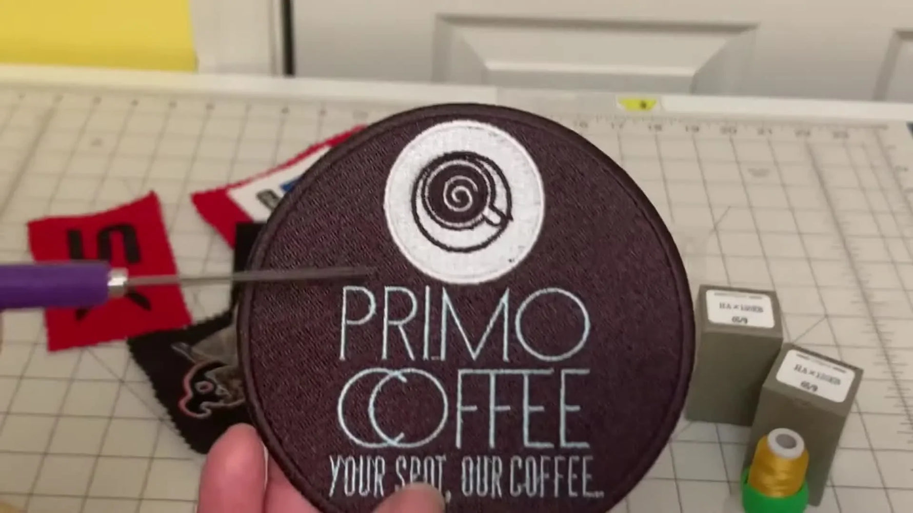 A close-up patch sample shows crisp, legible micro lettering on a dark background—exactly what 60wt thread and a 65/9 needle are meant to achieve.
