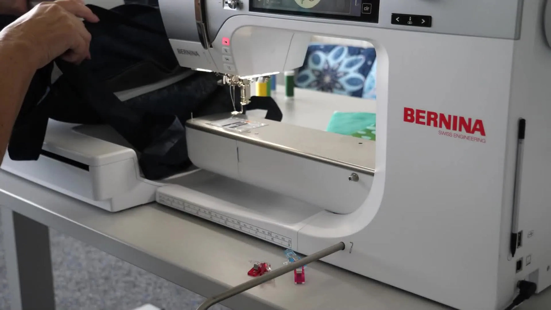 A hooped tubular tote bag is slid onto the Bernina free arm, showing the Large Freearm Hoop positioned for safe clearance and smooth stitching.