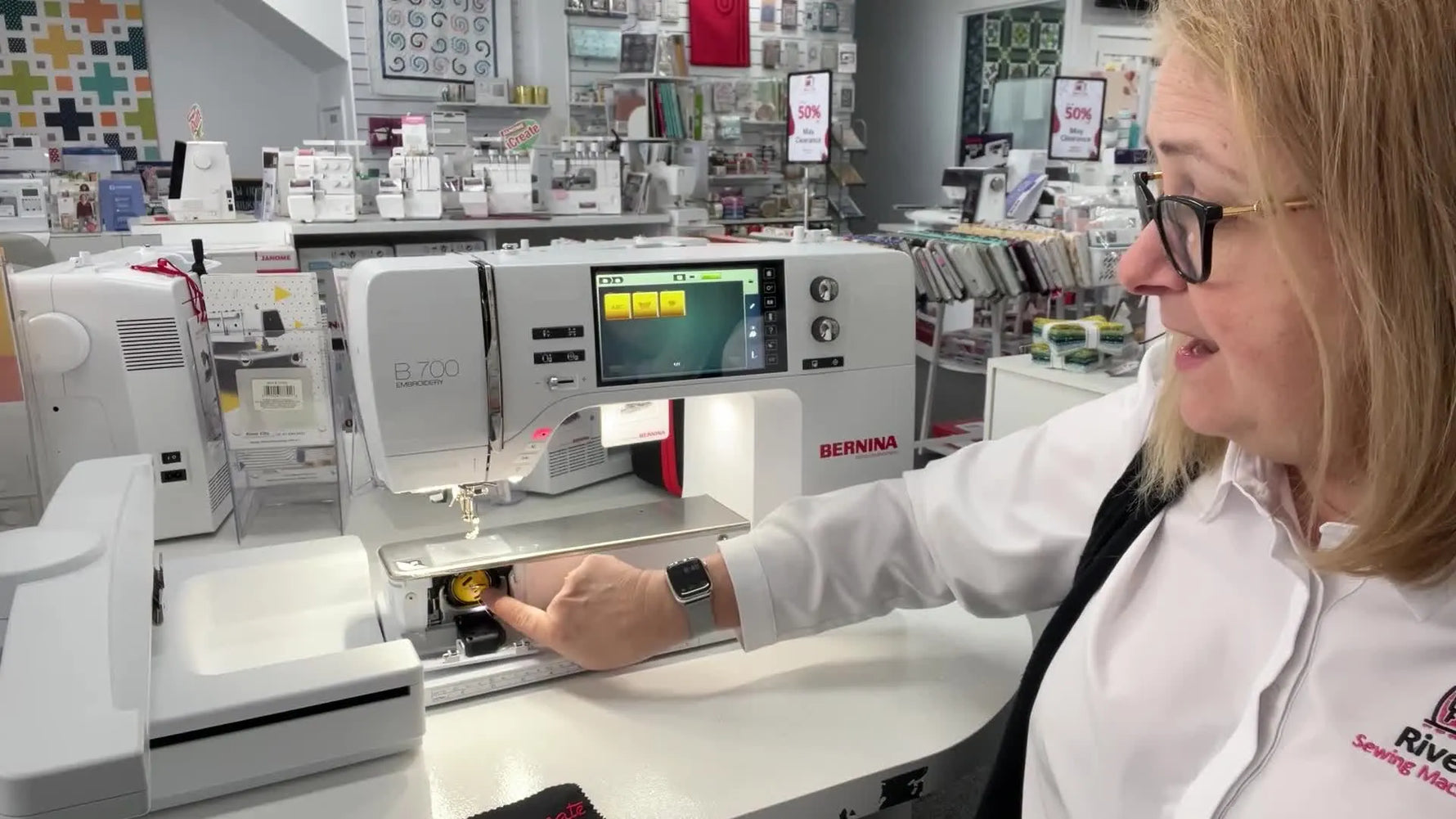 Close-up of the Bernina B700 bobbin area as the yellow high-tension bobbin case is removed for inspection.