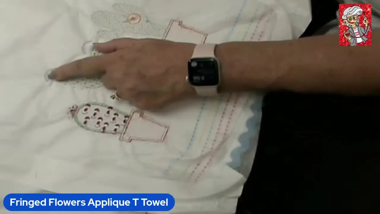 Close-up of sharp scissors cutting the white bobbin thread on the back of a hooped tea towel to prepare a 3D fringe flower effect.
