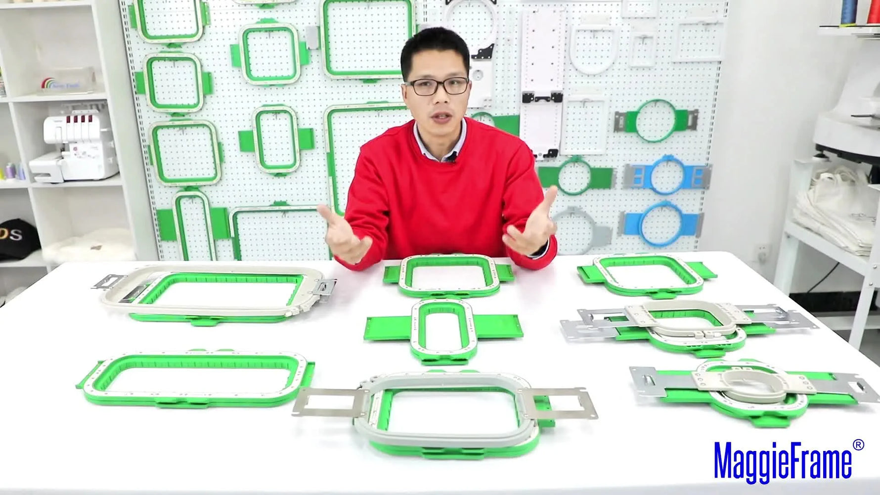 A wide tabletop layout of multiple green MaggieFrame magnetic hoops alongside grey Brother/BabyLock tubular hoops, showing the full size range at a glance.