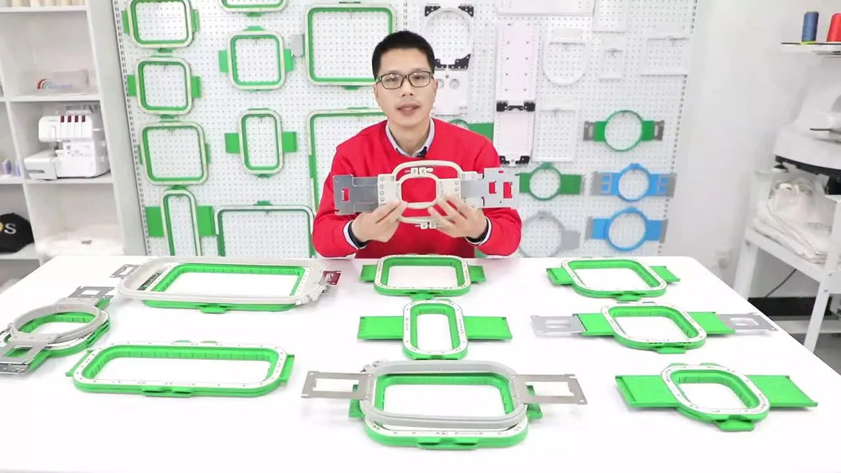 Presenter introduces MaggieFrame magnetic hoops and traditional Brother/Baby Lock hoops on a table.