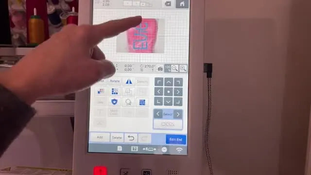 The Brother machine’s live camera view shows the name design precisely positioned over the plush puppy ear before stitching.